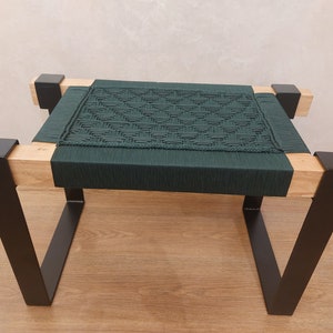 Puede incluir: Banco artesanal con asiento tejido verde oscuro y marco de madera natural. Las patas son de metal negro, creando una estética moderna y minimalista. El banco mide aproximadamente 46 cm de largo, 30 cm de ancho y 41 cm de alto.