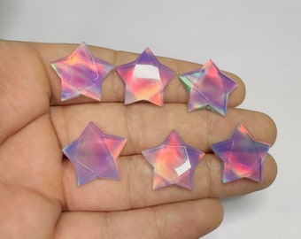 May include: Six iridescent purple, pink, and orange star-shaped cabochons. The cabochons are faceted and have a smooth, polished finish.