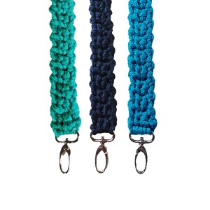 May include: Three crocheted keychains with silver clasps. The keychains are teal, navy blue, and turquoise.