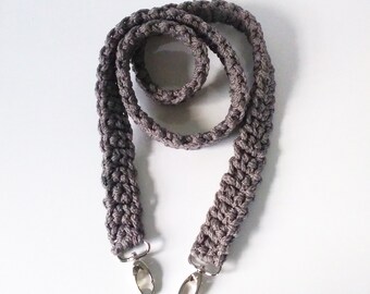 May include: A gray crocheted strap with silver clasps. The strap is about 40 inches long and is made of a thick, textured yarn.