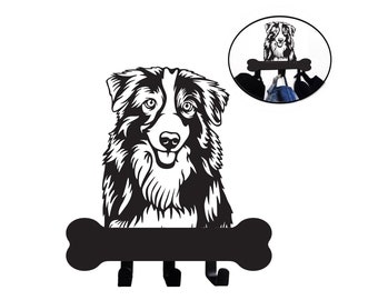 Puede incluir: Porta llaves de metal negro con forma de hueso con una silueta de un perro pastor australiano en la parte superior. El porta llaves tiene tres ganchos.