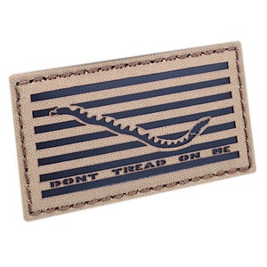 Könnte beinhalten: Ein gestickter Aufnäher in Tan und Schwarz mit einer Schlange und dem Text "DON'T TREAD ON ME".