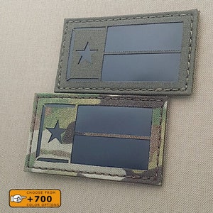 May include: Two embroidered patches featuring the Texas state flag. The patches are in different colour schemes, one is green and the other is camouflage. Both patches have a black background with a white star and two white stripes.