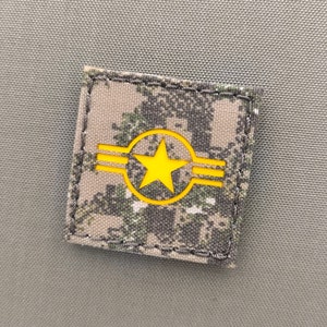 Peut inclure: Un patch en tissu camouflage avec une étoile jaune à trois bandes dans un cercle.