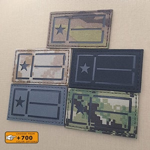 May include: Five different colour variations of a black and white embroidered patch with a star and two horizontal lines. The patch is available in a variety of camouflage patterns, including digital, woodland, and multicam.