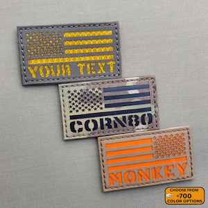 May include: Three rectangular patches with American flag designs. The top patch has gold text that reads "YOUR TEXT". The middle patch has the text "CORN80". The bottom patch has the text "MONKEY". The patches are on a gray background.