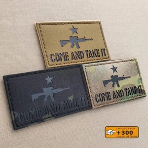 Peut inclure: Trois patchs brodés avec une silhouette noire d'un fusil et une étoile, avec le texte "Come and Take It" en noir. Les patchs sont sur des fonds de couleurs différentes : beige, noir et camouflage.