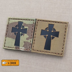 Peut inclure: Deux patchs de croix celtique noirs et blancs avec une bordure cousue. Les patchs sont sur un fond de tissu camouflage. Le texte "Choose from +300 Color Options" est sur un rectangle orange.