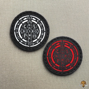 Op de afbeelding: Twee ronde zwarte patches met een religieus ontwerp. Eén patch heeft een wit ontwerp, de andere een rood ontwerp. Het ontwerp bevat een kruis, letters en het woord "PAX".