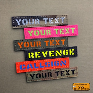 Könnte beinhalten: Sechs verschiedene farbige gestickte Patches mit dem Text "YOUR TEXT", "REVENGE" und "CALLSIGN". Die Patches befinden sich auf einem braunen Hintergrund. Wählen Sie aus über 700 Farboptionen.