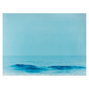 May include: A serene seascape painting dominated by shades of blue. The artwork depicts a calm ocean under a pale blue sky. Gentle waves are visible near the bottom, adding depth to the minimalist composition. The overall mood is tranquil and calming.