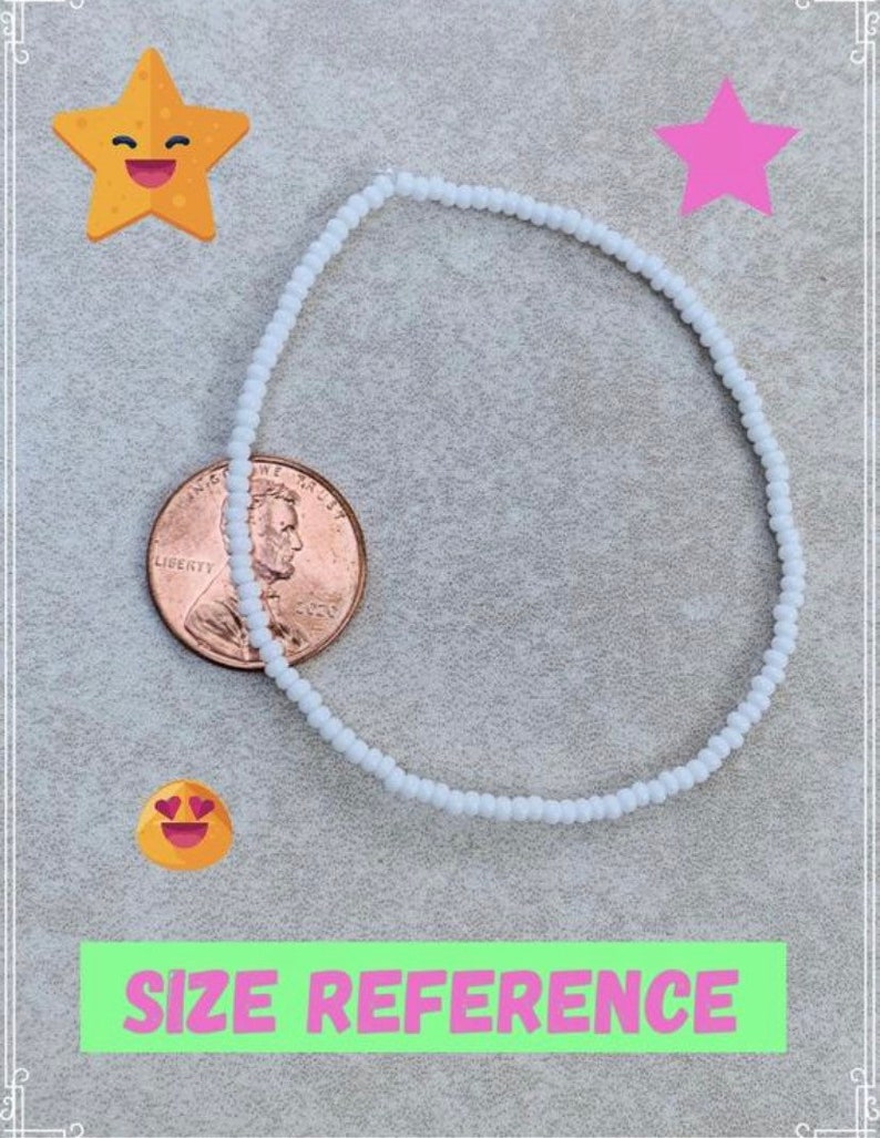 May include: A white beaded bracelet next to a US penny for size reference. The bracelet is made of small, round beads.