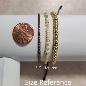 May include: Three beaded bracelets in different sizes, shown next to a US penny for size reference. The bracelets are 6/0, 8/0, and 11/0 sizes.