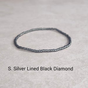 May include: A silver lined black diamond beaded bracelet.