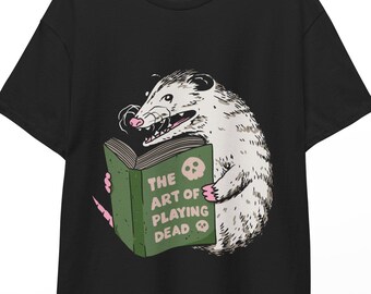 Un opossum lisant un livre L'art de faire le mort T-shirt unisexe