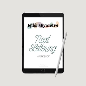 May include: A digital tablet screen displaying a workbook titled "Neat Lettering Workbook" with the text "lettersbyandre" and colorful abstract shapes at the top. A white stylus is lying next to the tablet.
