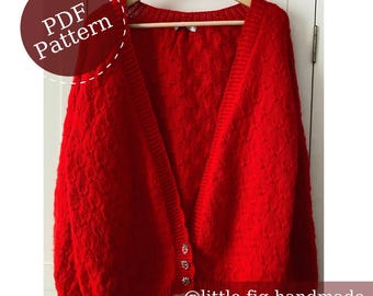 May include: A bright red knitted cardigan featuring a textured cable knit pattern, a V-neckline, and three small strawberry-shaped buttons. The garment is displayed on a wooden hanger and includes the text PDF Pattern and @little.fig.handmade.