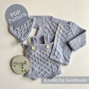 May include: A grey knitted baby outfit set with a cardigan, dungarees, and a hat. The set features a diamond pattern and wooden buttons. The image includes the text "PDF Pattern" and "@little.fig.handmade".