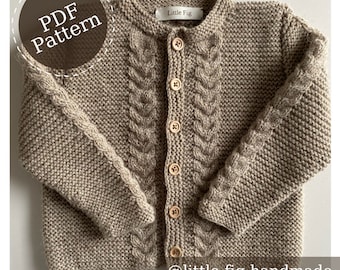May include: A beige knitted cardigan with a cable knit pattern and wooden buttons. The cardigan has a label that says "Little Fig".