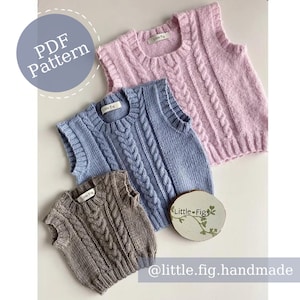 May include: Three knitted vests in different colors: pink, blue, and brown. Each vest has a cable knit pattern and a round neckline. The vests are laid out on a white surface. The text "Little Fig" is visible on a wooden tag.