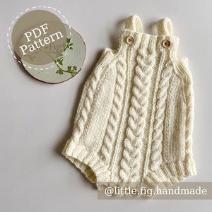 May include: A white knitted baby romper with a cable knit pattern and straps. The romper has two wooden buttons on the front. The image includes the text "PDF Pattern" and "@little.fig.handmade".