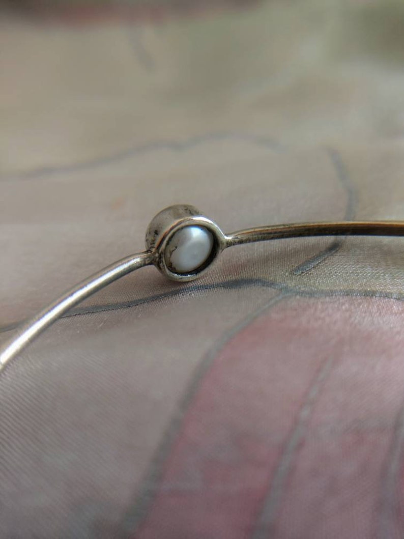 Silver bangle bracelet with four white pearls