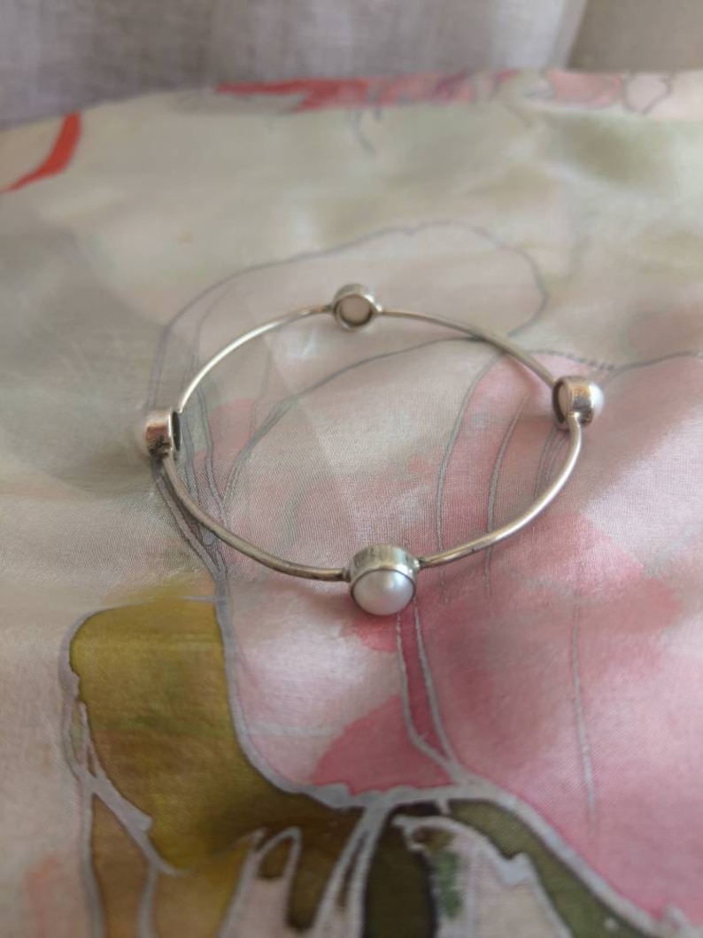 Silver bangle bracelet with four white pearls