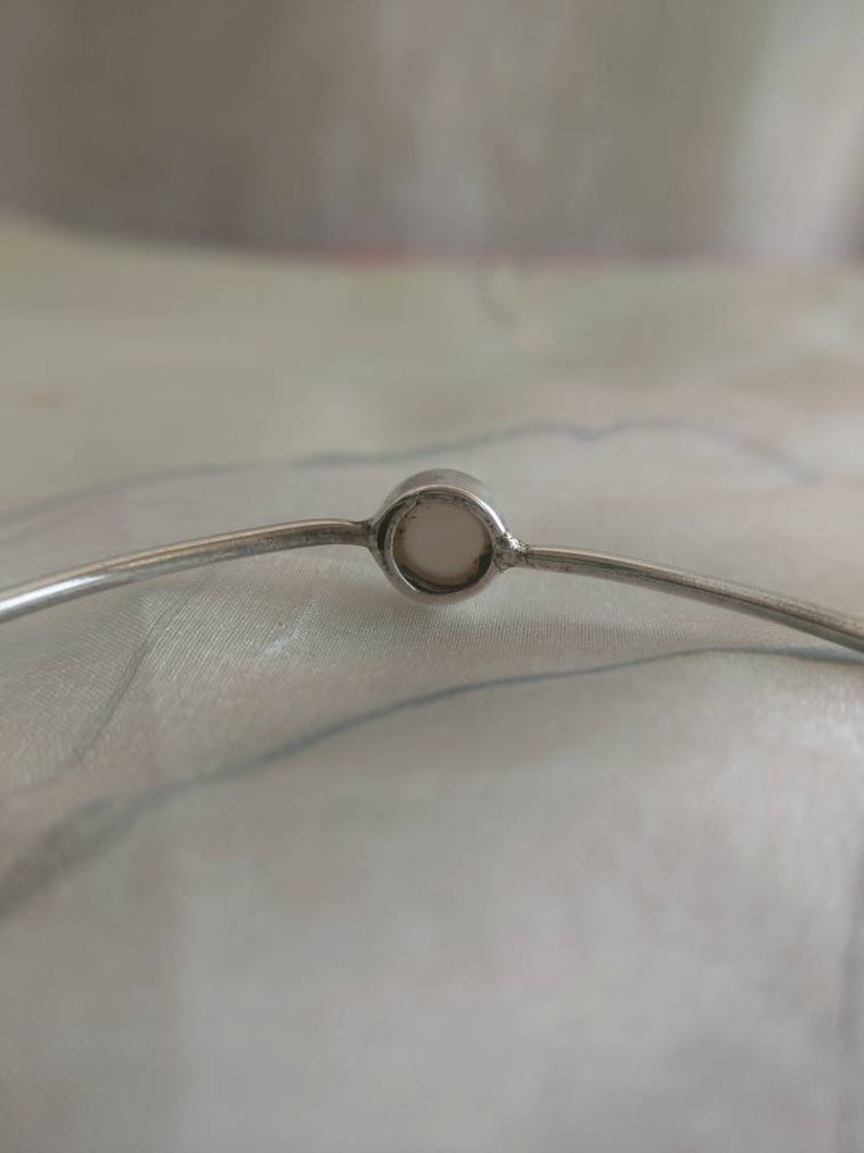 Silver bangle bracelet with four white pearls