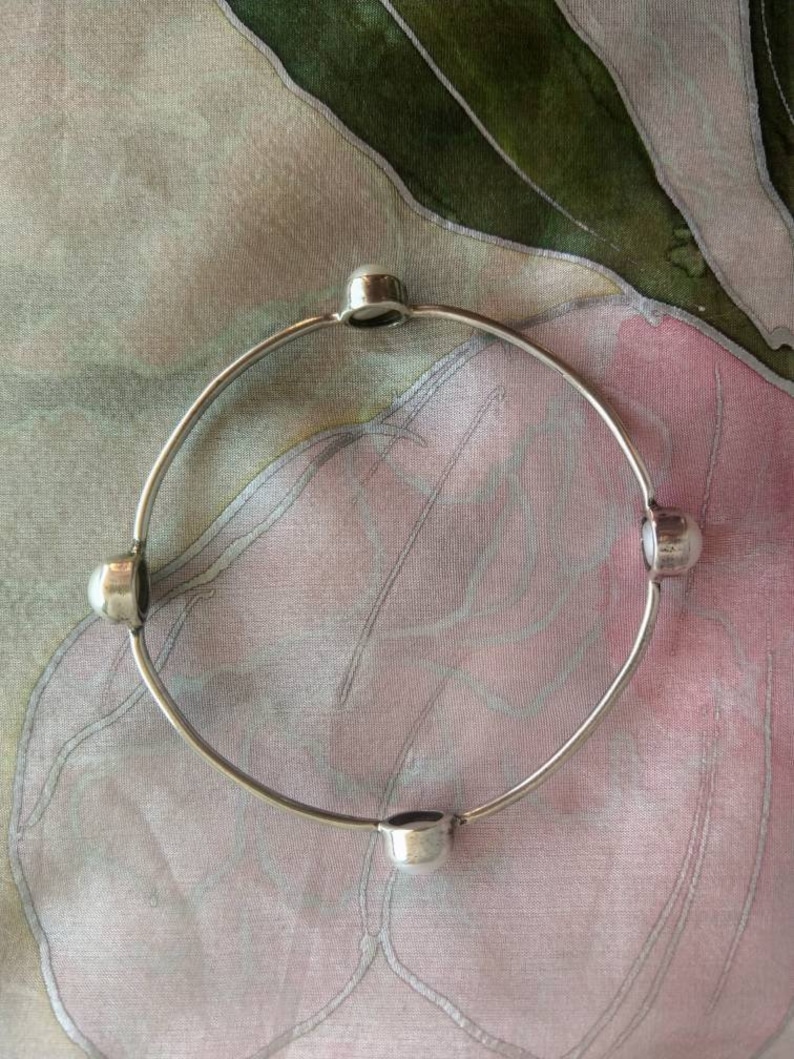 Silver bangle bracelet with four white pearls