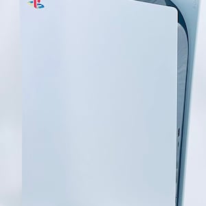 May include: A white PlayStation 5 console with the PlayStation logo on the front. The console is standing upright on a black base.