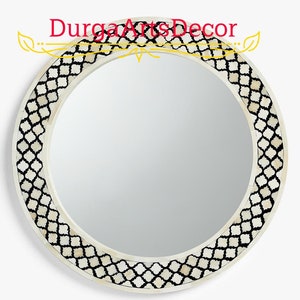 Puede incluir: Espejo redondo con marco de incrustaciones de hueso blanco y negro. El marco presenta un patrón geométrico.