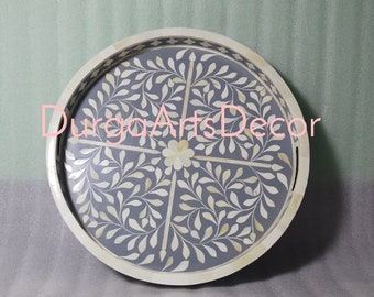 May include: A round tray with a gray background and a white floral design. The tray is made of bone inlay and has a decorative border.