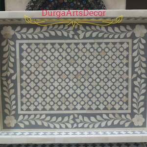 K&ouml;nnte beinhalten: Ein graues und wei&szlig;es Serviertablett aus Knocheninlay mit floralem Design und geometrischem Muster. Das Tablett hat einen wei&szlig;en Rand und zwei Griffe an den Seiten. "DurgArtsDecor" ist in goldenen Buchstaben auf der Oberseite des Tabletts geschrieben.