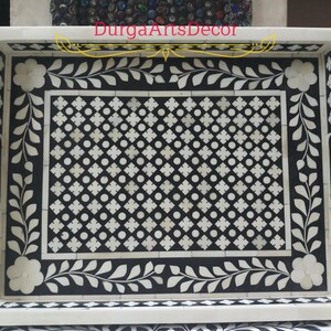 A grey and white bone inlay serving tray with a floral design and a geometric pattern. The tray has a white border and two handles on the sides. "DurgArtsDecor" is written in gold lettering on the top of the tray.
