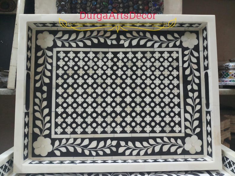 A grey and white bone inlay serving tray with a floral design and a geometric pattern. The tray has a white border and two handles on the sides. "DurgArtsDecor" is written in gold lettering on the top of the tray.