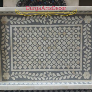 A grey and white bone inlay serving tray with a floral design and a geometric pattern. The tray has a white border and two handles on the sides. "DurgArtsDecor" is written in gold lettering on the top of the tray.