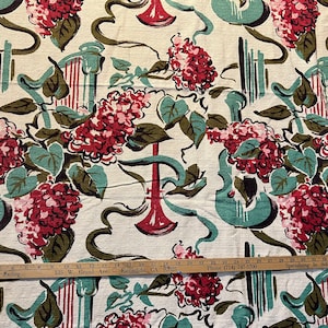 May include: A vintage fabric with a repeating pattern of red and white flowers, green leaves, and abstract musical instruments. The fabric has a white background and is printed with a light blue, green, and brown color scheme.