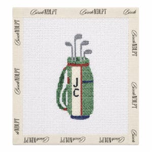 May include: A needlepoint canvas featuring a green golf bag with a white center stripe, red trim, and the initials JC in black. The bag contains four golf clubs and is set against a white grid background with the text BirchNDLPT on the border.