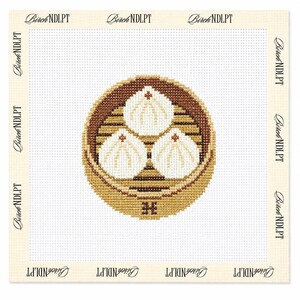 May include: A needlepoint canvas featuring a cross-stitched design of three white steamed buns inside a brown bamboo steamer basket. The text Birch NDLPT is printed repeatedly along the cream-colored border of the square white grid canvas.