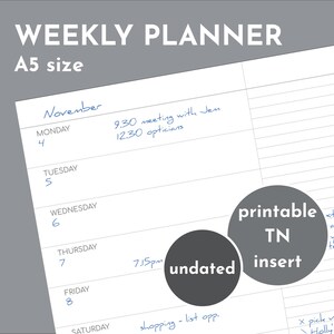Peut inclure: Un planificateur hebdomadaire blanc de format A5 avec le texte "WEEKLY PLANNER" en haut. Le planificateur comprend des pages d'insert TN non datées. Le planificateur contient des notes manuscrites à l'encre bleue.