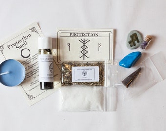 Peut inclure: Un kit de sortilège de protection avec une bougie bleue, une bouteille d'huile, un sachet d'herbes, un sachet de sel, une petite fiole avec un cristal, une pierre bleue, une pierre grise avec une rune et une petite pierre grise. Le kit comprend également une carte avec le mot "Protection" et un symbole de rune.