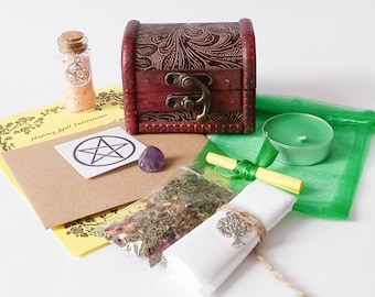 Peut inclure: Une boîte en bois avec un symbole de pentagramme, une petite bouteille de sel rose, une bougie verte, un petit sachet d'herbes, un tissu blanc avec un charme d'arbre, une note jaune et un cristal d'améthyste.