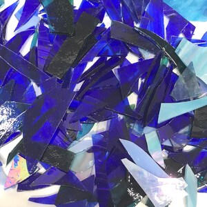 Op de afbeelding: Een stapel blauwe en iriserende glasscherven, perfect voor knutsel- of moza&iuml;ekprojecten.