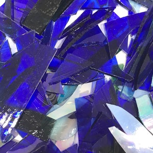 Op de afbeelding: Een stapel blauwe en zwarte glasscherven, perfect voor knutsel- of moza&iuml;ekprojecten.