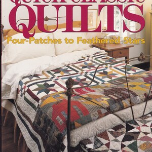 May include: A bed with a patchwork quilt featuring star and geometric patterns in various colors. The quilt covers the bed, which has a metal frame. The image also shows a book cover with the title "Quick Classic Quilts".