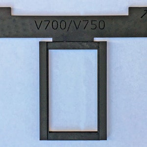 May include: Black plastic frame with a rectangular opening and the text "V700/V750" on the top.