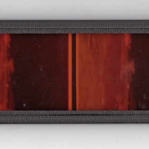 May include: A close-up of a film strip with two frames showing a red and orange gradient.