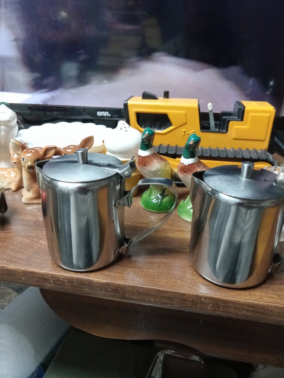 A pair of stainless steel creamers