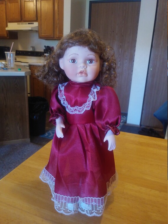Porcelain Doll #109 with red satin and lace dress circa. 1980s