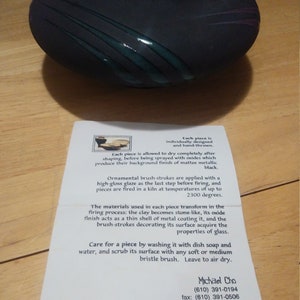 May include: A black ceramic bowl with a green glaze design. The bowl is hand-thrown and individually designed. Each piece is fired in a kiln at temperatures of up to 2300 degrees. Care for the piece by washing it with dish soap and water, and scrub its surface with a soft or medium bristle brush. Leave to air dry. Michael Cho (610) 391-0194 fax: (610) 391-0506 http://mikecho.cjb.net